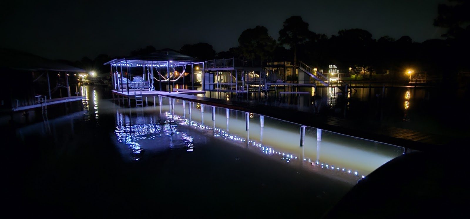 Lakeside Texas home glowing with warm amber permanent lighting at dusk